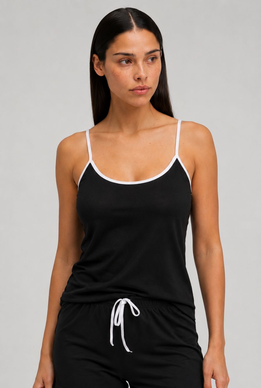 Modelo usando pijama feminino conjunto aurora preto com blusa de alças e short com cordão em vista aproximada