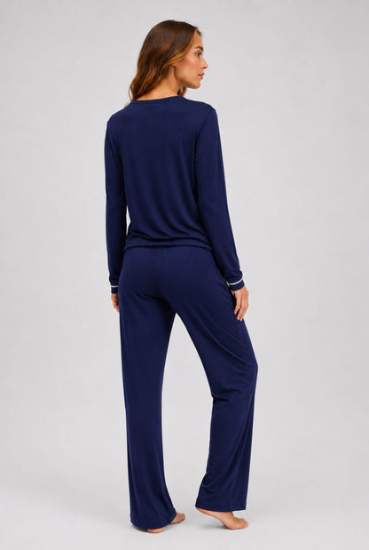 Modelo usando pijama feminino conjunto paris azul marinho com blusa longa e calça em pose de costas