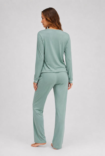 Modelo usando pijama feminino conjunto paris verde mint com blusa longa e calça em pose de costas