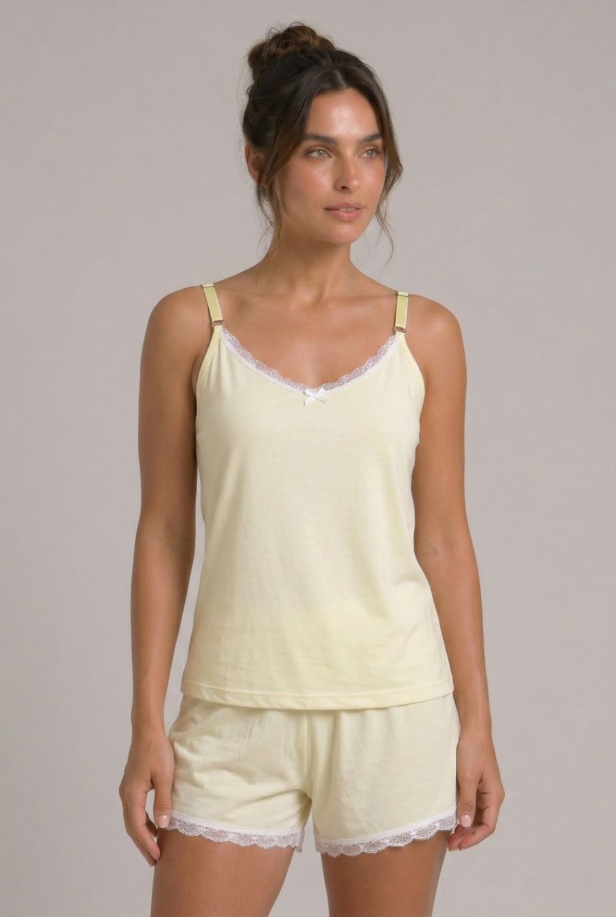 Modelo usando pijama feminino conjunto Veneza amarelo com blusa de alças, short e detalhe em renda branca