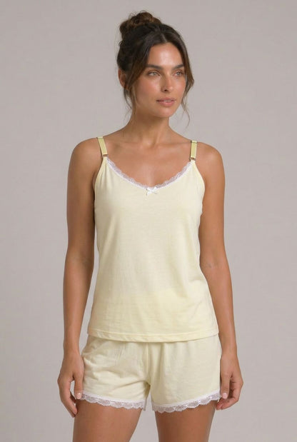 Modelo usando pijama feminino conjunto Veneza amarelo com blusa de alças, short e detalhe em renda branca