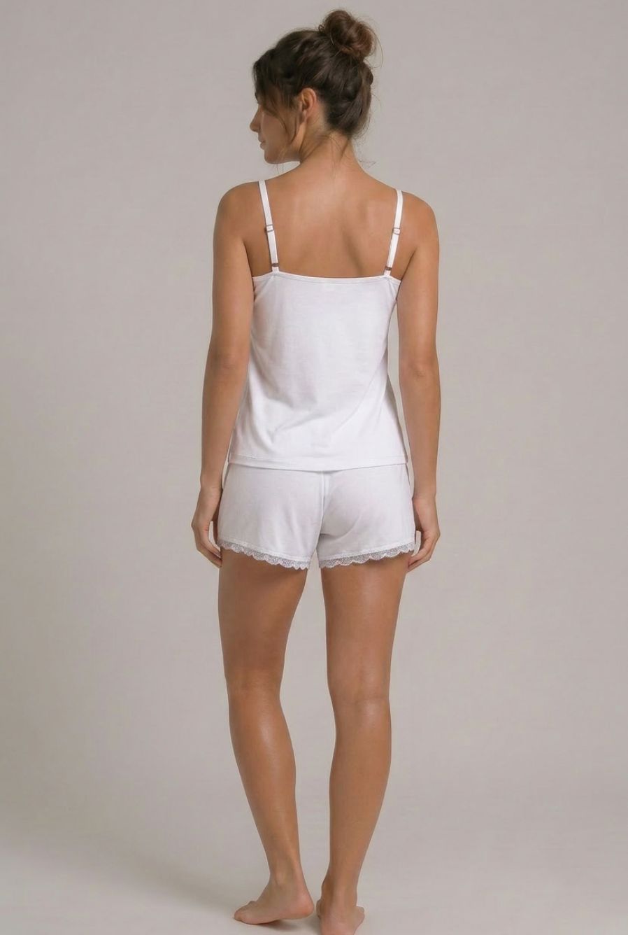 Modelo usando pijama feminino conjunto Veneza branco com blusa de alças, short e detalhe em renda branca em vista traseira
