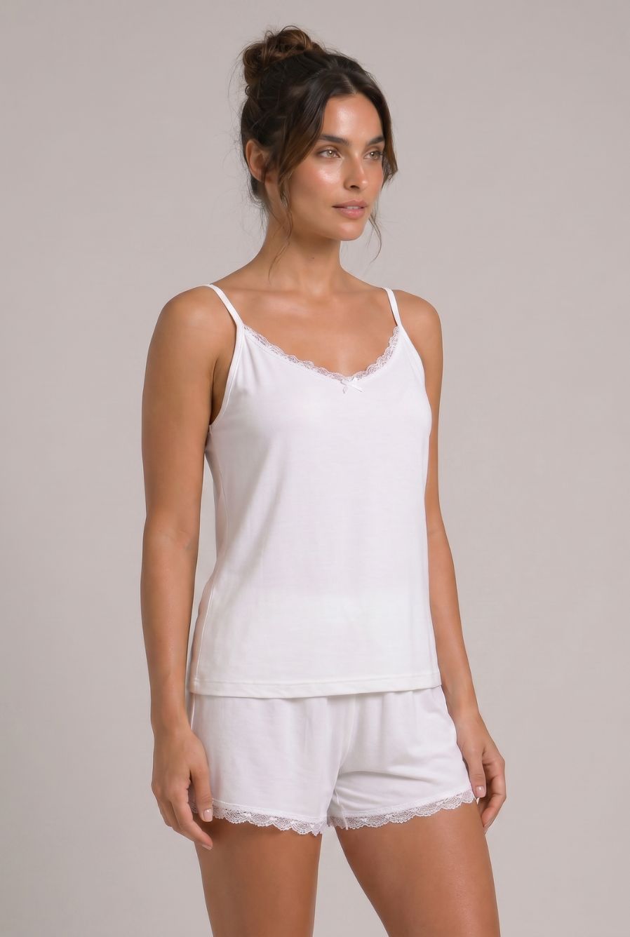 Modelo usando pijama feminino conjunto Veneza branco com blusa de alças, short e detalhe em renda branca