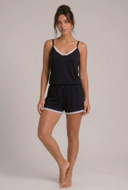Modelo usando pijama feminino conjunto Veneza preto com blusa de alças, short e detalhe em renda branca